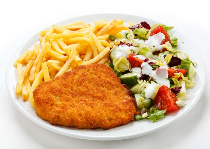 Breaded meat with french fries and salad on a plate