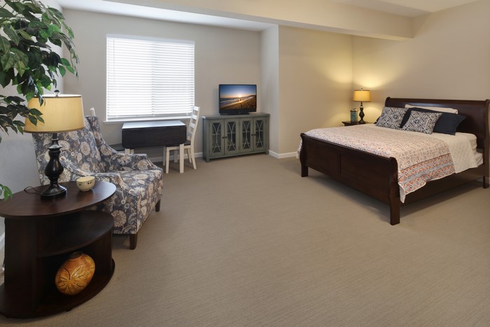 Bedroom with bed, chair, and TV