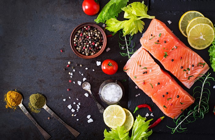 Salmon fillets with spices, tomatoes, lemons, and herbs