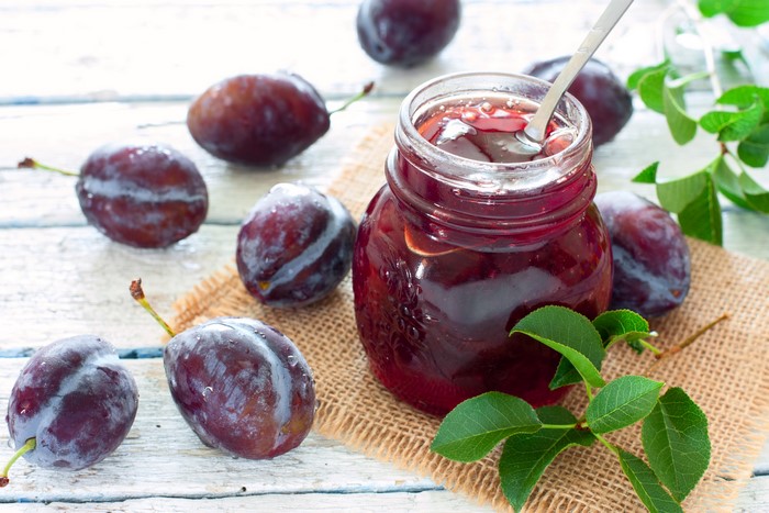 Plum jam in a jar with fresh plums