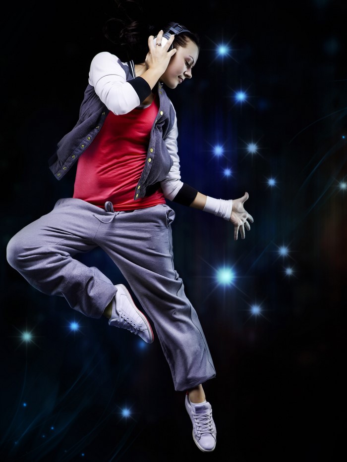 Dancer with headphones jumping with blue lights