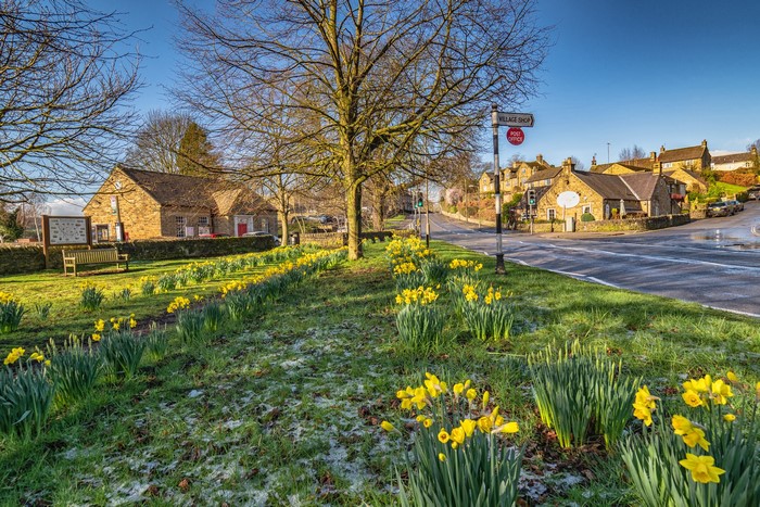 Village shop and post office with daffodils in Baslow, Derbyshire