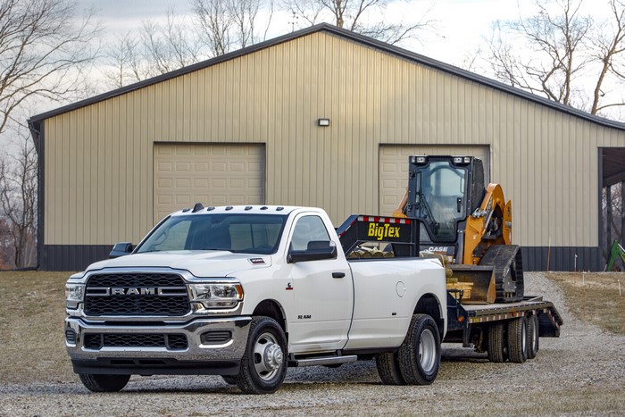 White Ram 3500 Tradesman Dually towing a skid steer loader