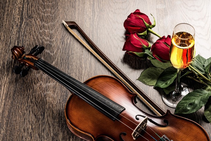 Violin, Roses, and Champagne on Wooden Surface