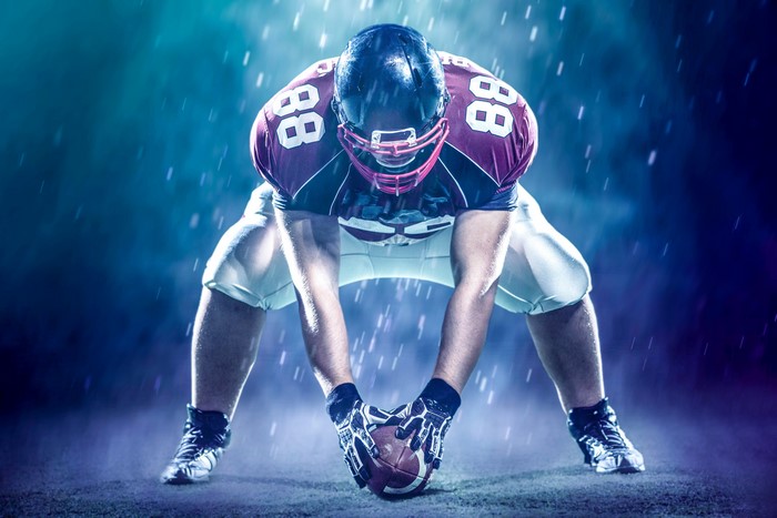 American football player in uniform with helmet and ball
