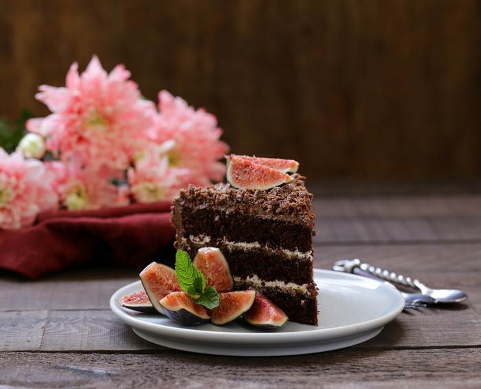 Chocolate cake slice with figs and flowers