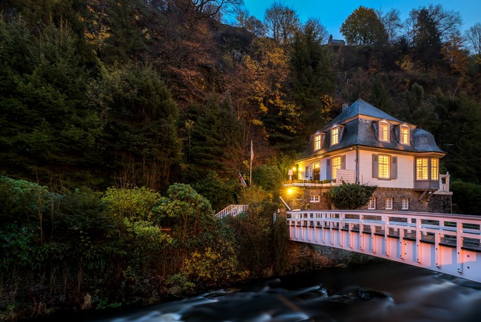 House and bridge over river in Monschau, Germany at dusk