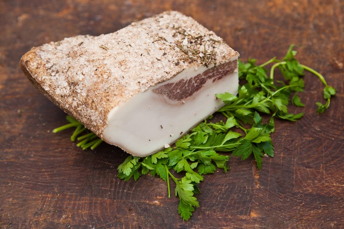 Salo with herbs and parsley on a wooden board