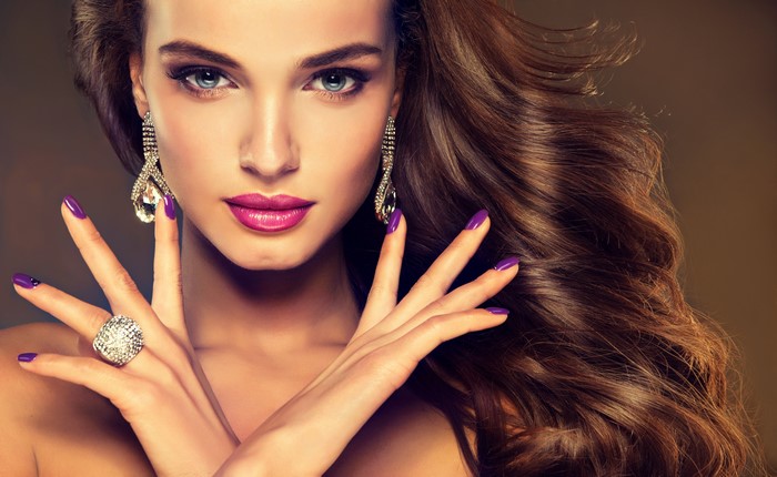 Woman with Brown Hair, Earrings, and Purple Manicure