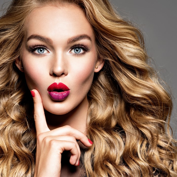 Woman with curly blonde hair and red lips