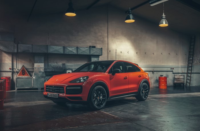 Orange Porsche Cayenne Turbo Coupe in a garage