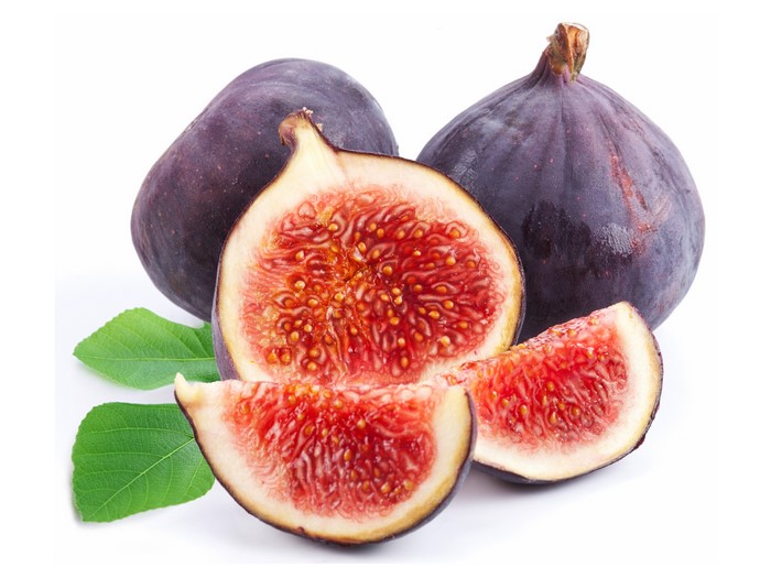 Common fig cut in half and sliced on white background