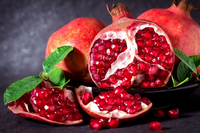 Pomegranates with leaves on a dark background