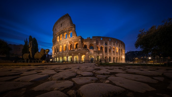 Colosseum at Night with Cobblestone Pavement in Rome, Italy