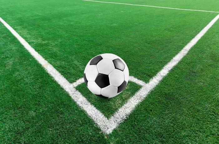 Soccer ball on a green soccer field corner