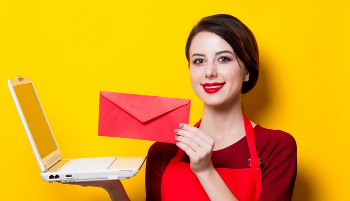 Woman holding a laptop and a red envelope