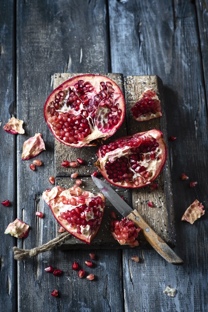Pomegranate on a cutting board with a knife