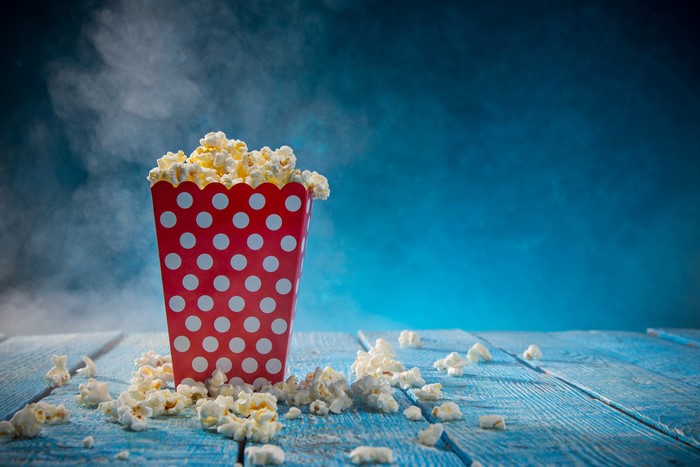Popcorn in a red polka dot bucket on wood planks
