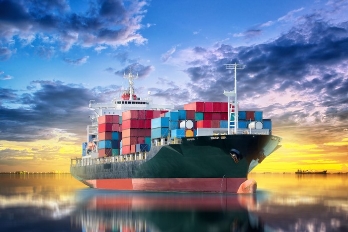 Container ship sailing on the ocean at sunset