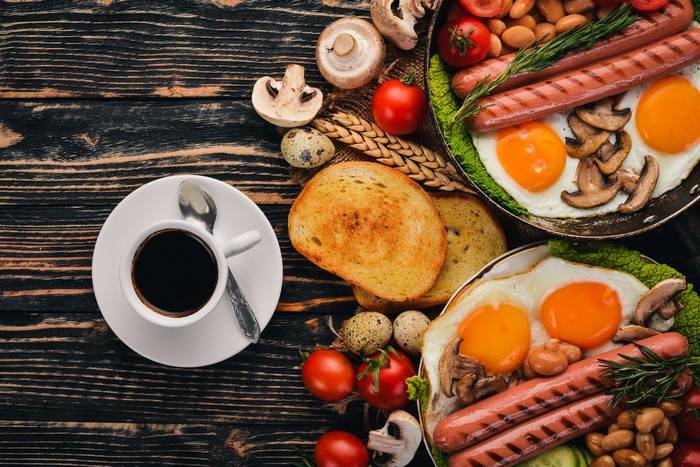 Breakfast with coffee, sausages, fried eggs, and toast