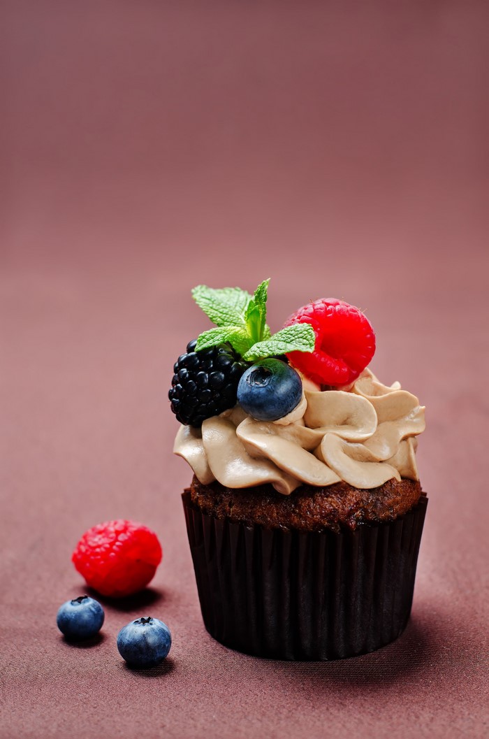 Chocolate cupcake with berries and frosting