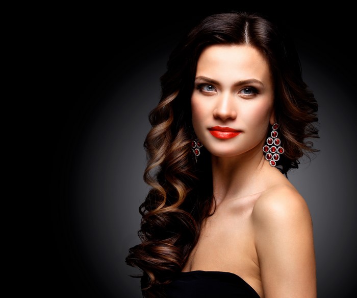 Woman with brown curly hair and red lips