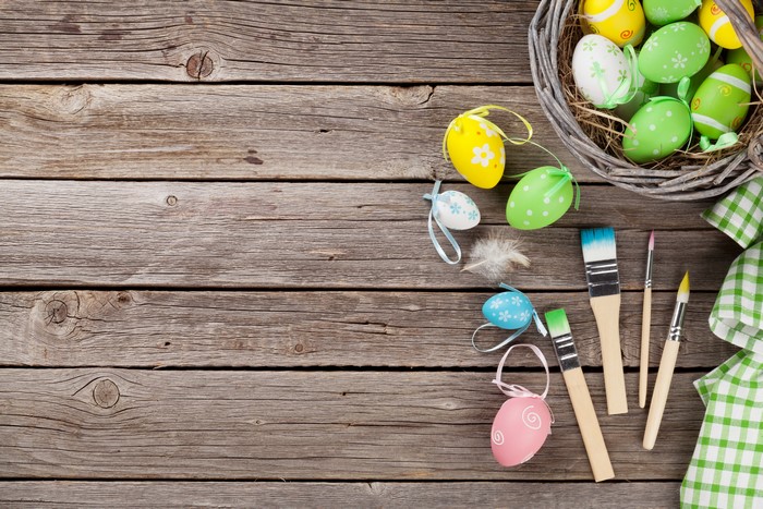 Easter eggs and paintbrushes on wood planks
