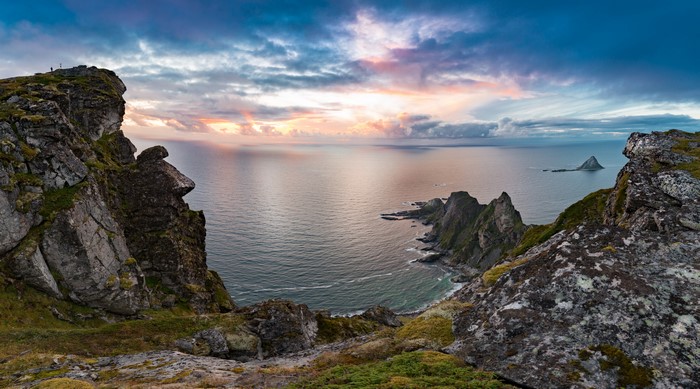 Sunset over the Norwegian coast with rocky cliffs