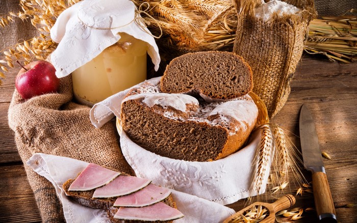 Bread, Ham, and Wheat on a Wooden Table