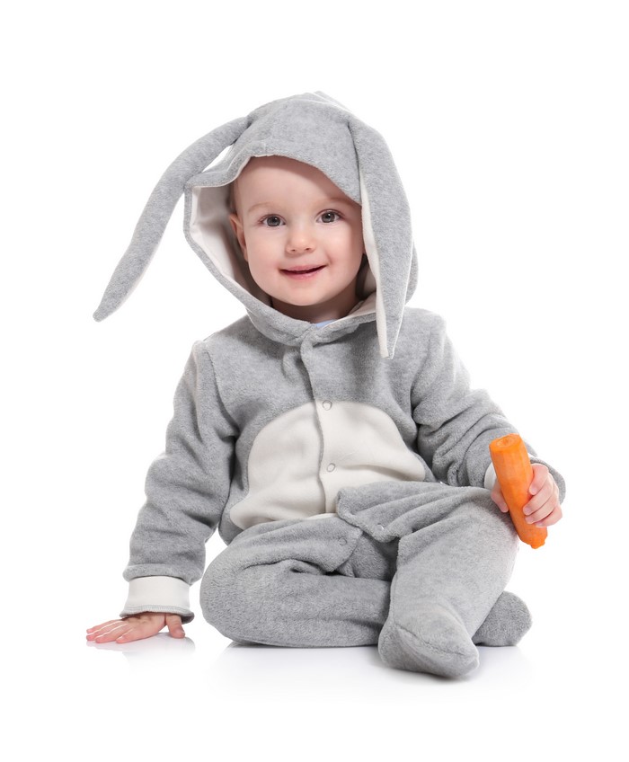 Baby in a bunny costume holding a carrot