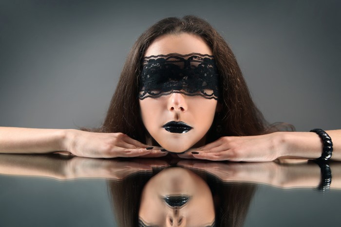 Woman with black lace mask and lipstick