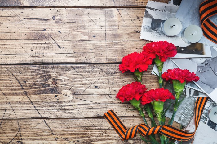 Red Carnations and Victory Day Symbols on Wood