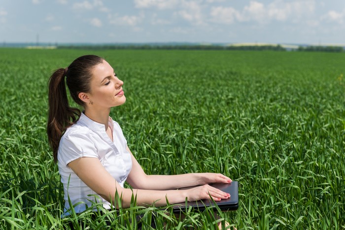 Woman with laptop in a field