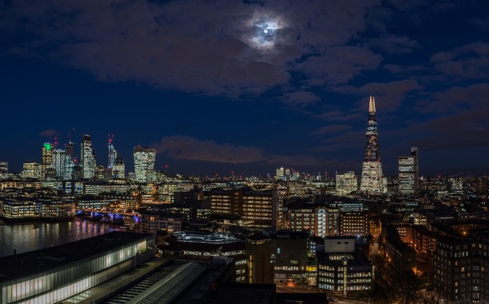 London skyline at night with moon and clouds