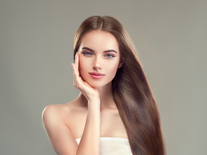Brown haired woman with hand on face