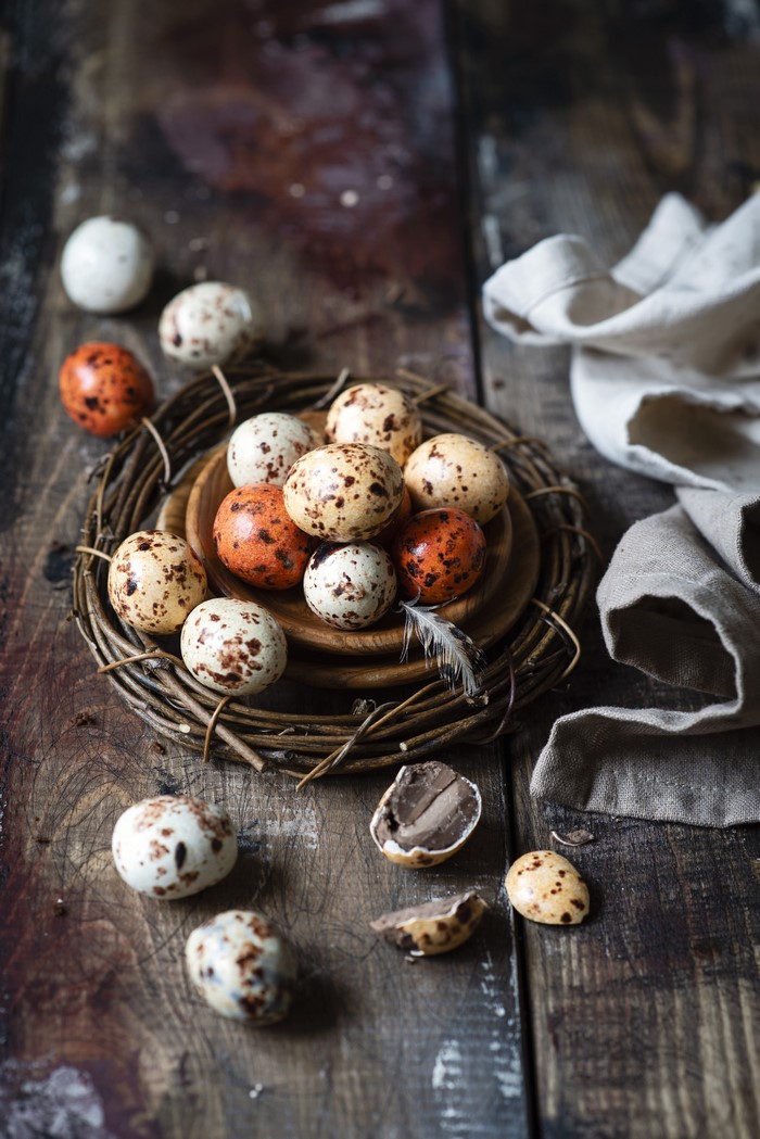 Easter eggs in a nest on a wooden table
