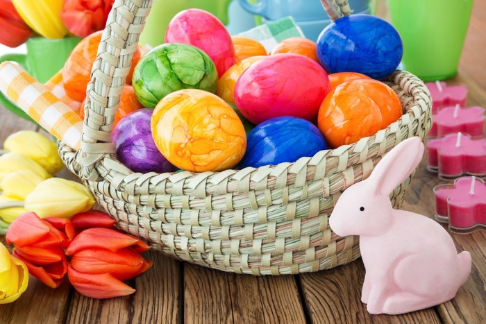 Easter eggs in a wicker basket with tulips and a bunny