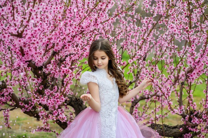 Girl in a dress among flowering trees