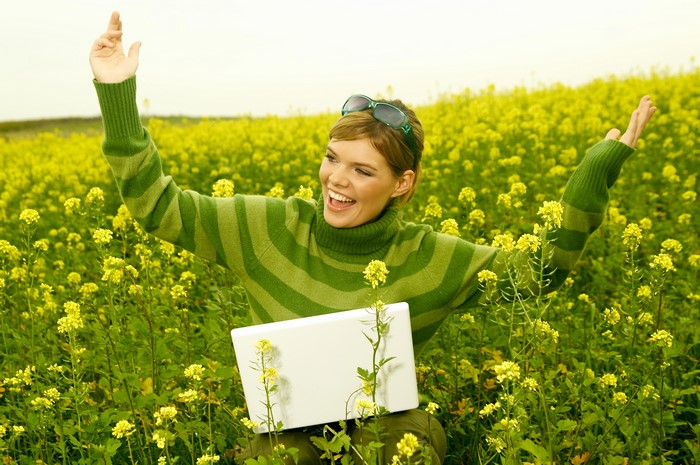 Woman in a field with a laptop