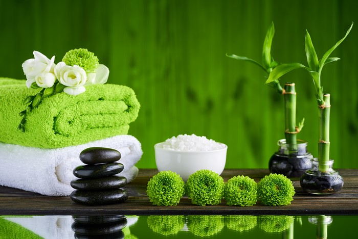 Spa towels, stones, salt, flowers, and bamboo