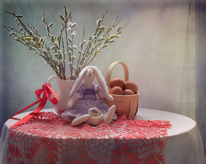 Easter still-life with bunny doll, eggs, and pussy willow branches