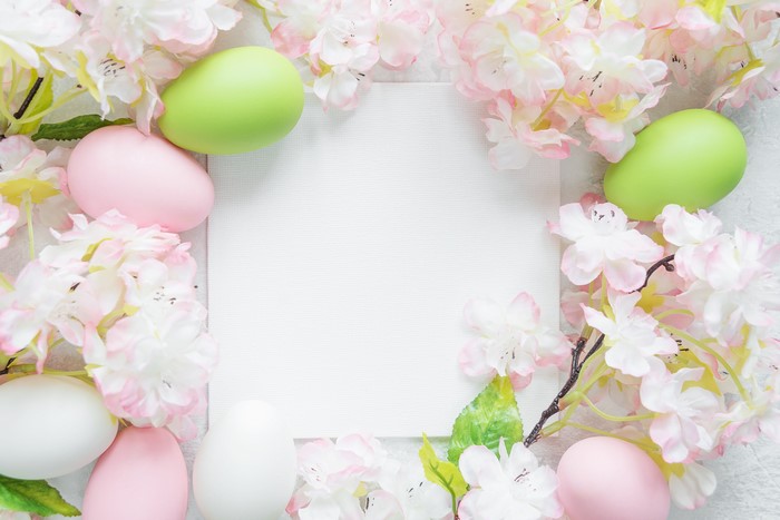 Easter eggs and flowers with a blank sheet of paper