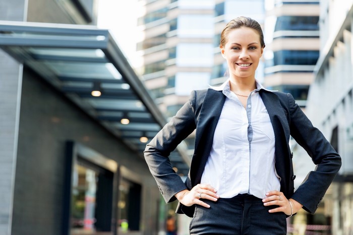 Businesswoman in a suit standing outside office buildings