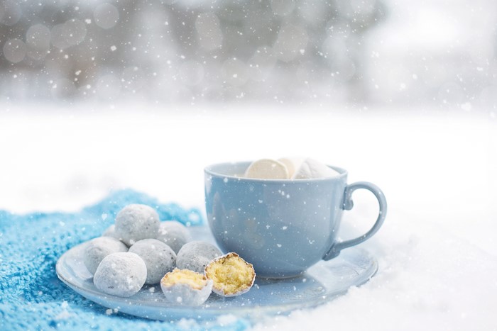 Cup of hot chocolate with marshmallows and cookies in snow