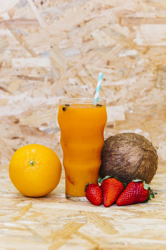 Orange juice with strawberries, coconut, and orange