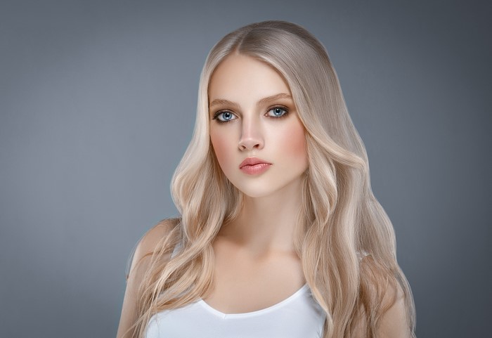 Blonde woman with blue eyes on a gray background