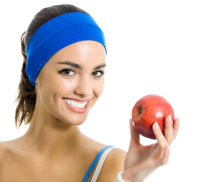 Woman with blue headband holding a red apple
