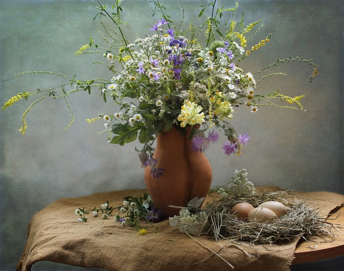 Wildflowers in a vase with a nest and eggs