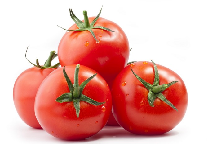 Tomatoes with water droplets on white background