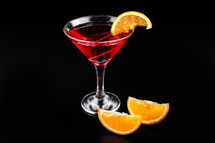 Cocktail with orange slice on black background